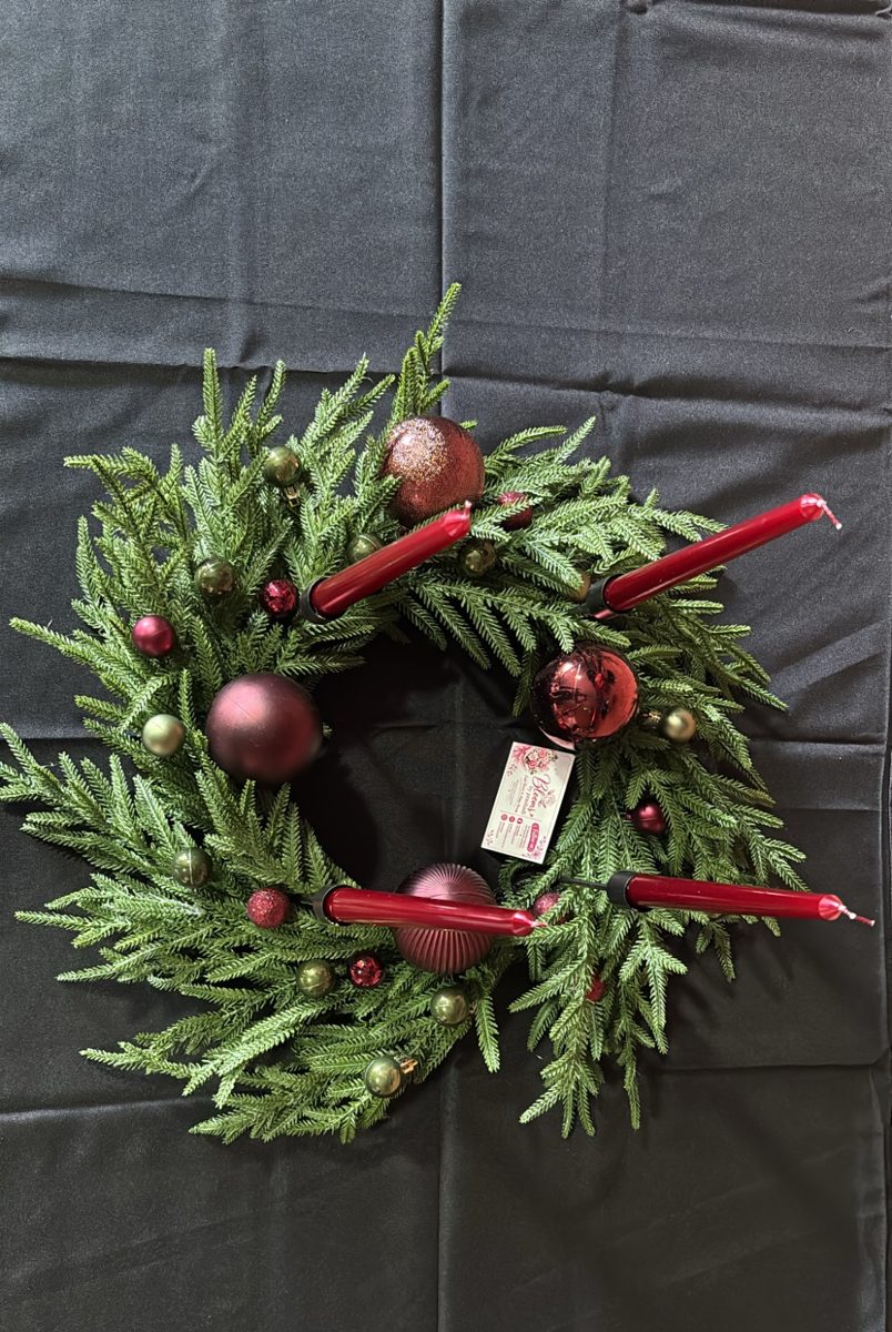 Green pine advent wreath with red baubles and four red candles