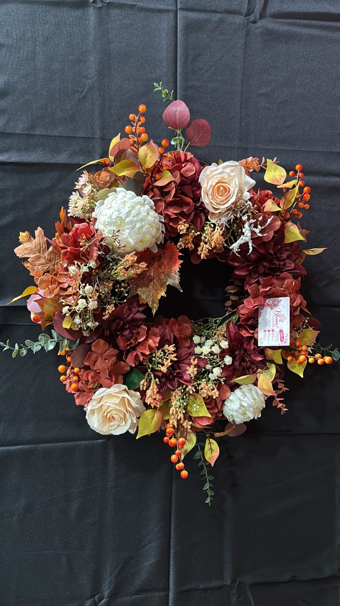 Autumn wreath of rust and cream flowers, autumn leaves and orange berries